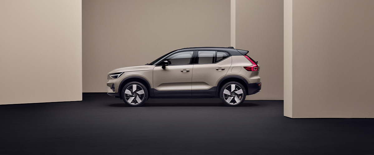 En sandfarget Volvo EX40 fra siden